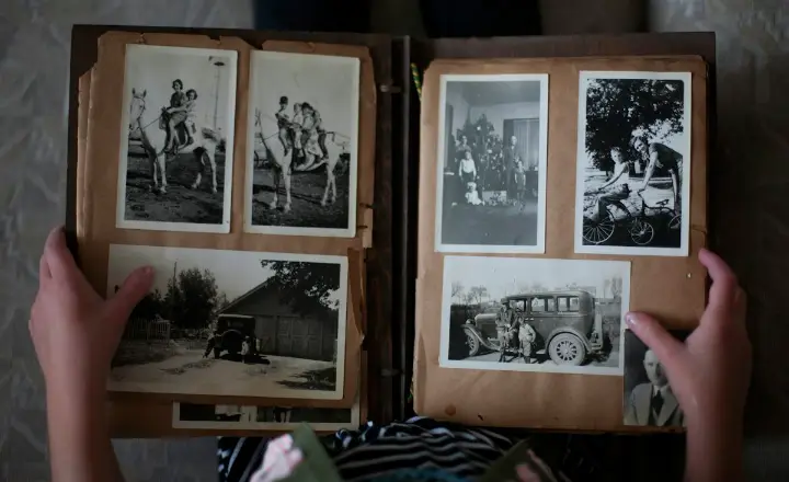 Hands turning the pages of an old family photo album
